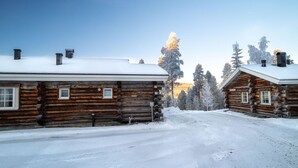 A log cabin with a snow-covered roof and a clear sky.