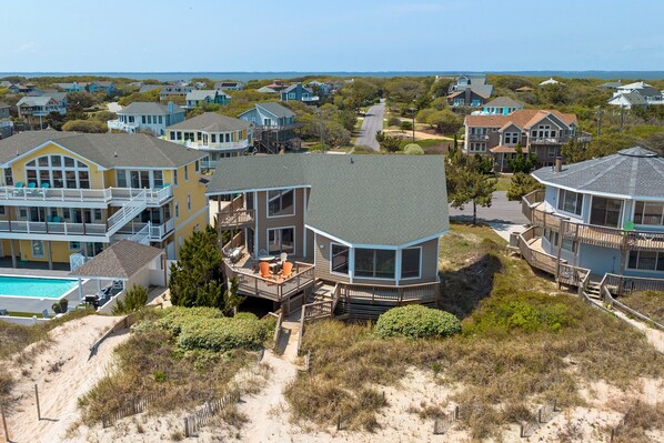 A coastal house with a large deck and a swimming pool.
