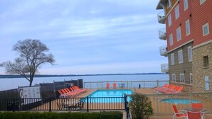 A hotel with a pool area, outdoor seating, and a view of the lake.