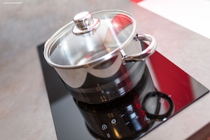 Enjoy cooking with the modern electric kettle on the sleek induction cooktop.