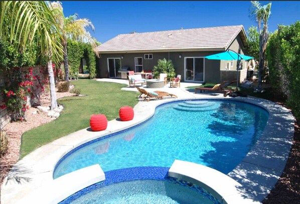 Enjoy a pool and outdoor seating areas amidst a beautifully maintained lawn.