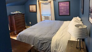 A bedroom with a large bed, a dresser, a window with blinds, and a ceiling fan. - Classy AF Home Steps from Colby and Trails (Oakland)