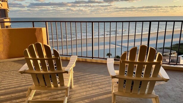 Two Adirondack chairs on a balcony overlooking a beach with a railing. - Premium-Steps 2 Beach-Wide Oceanview-Lrg Balconies-Pool-Gated-On Site Restaurant (Myrtle Beach)