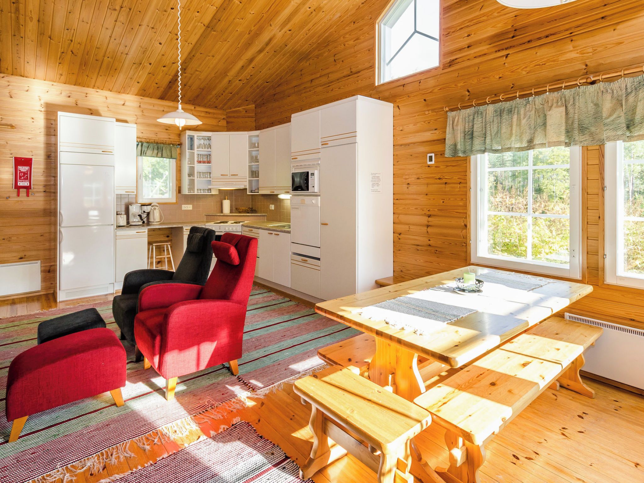 Interior acogedor de una cabaña con comedor, cocina y zona de estar.