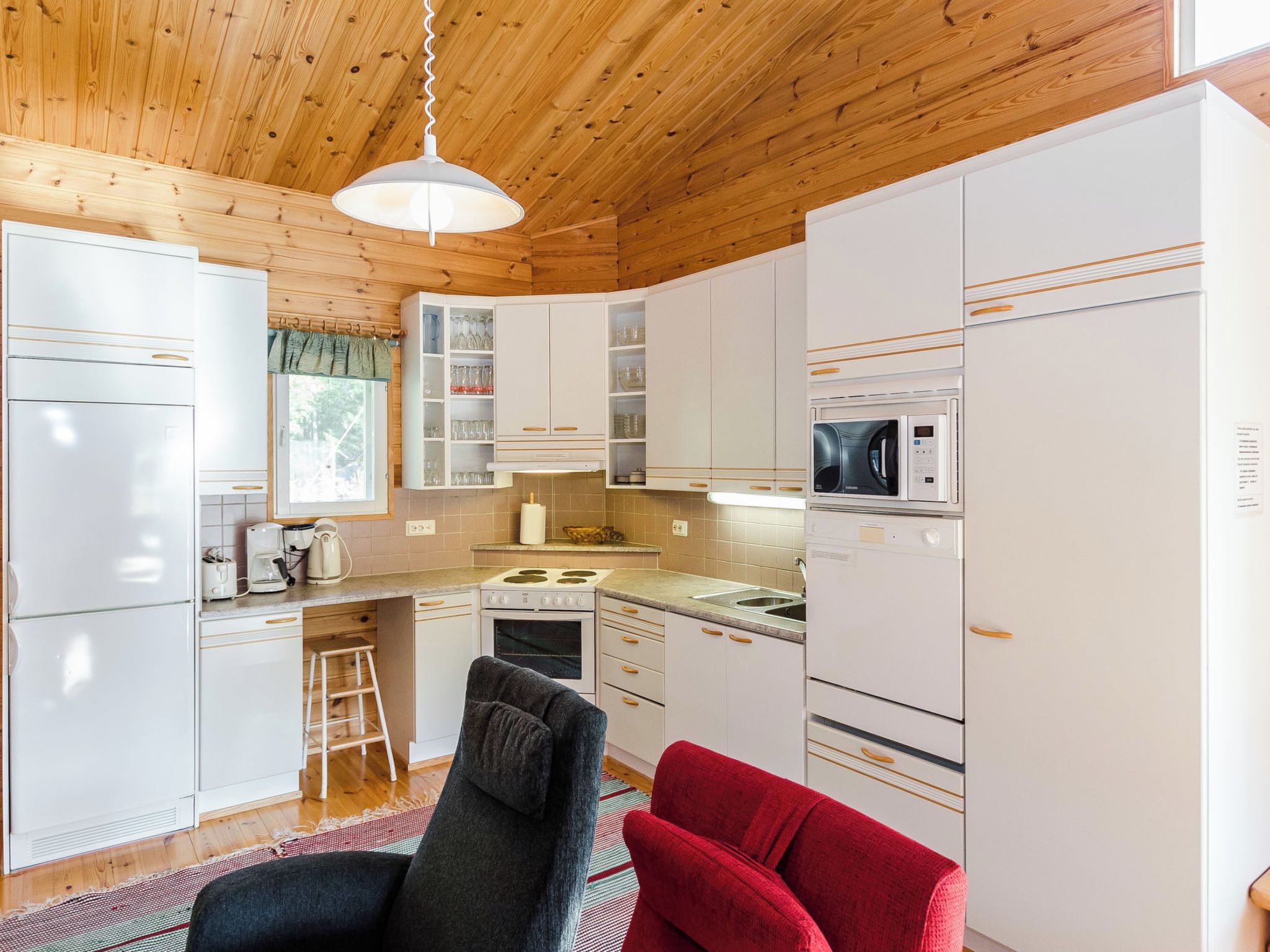 A modern kitchen with white cabinets, a microwave, a stove, and a sink.
