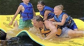 A group of people on a yellow inflatable raft in a body of water.