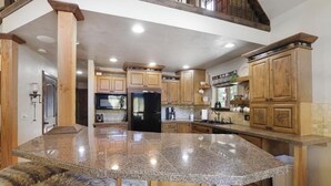 Una cocina amplia con encimeras de granito, armarios de madera y una isla central.