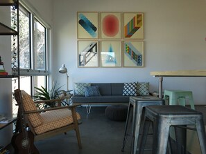 A living room with a sofa, a chair, a table, and a guitar. There are six framed artworks on the wall. - Modern design retreat in Downtown Durango (Durango)