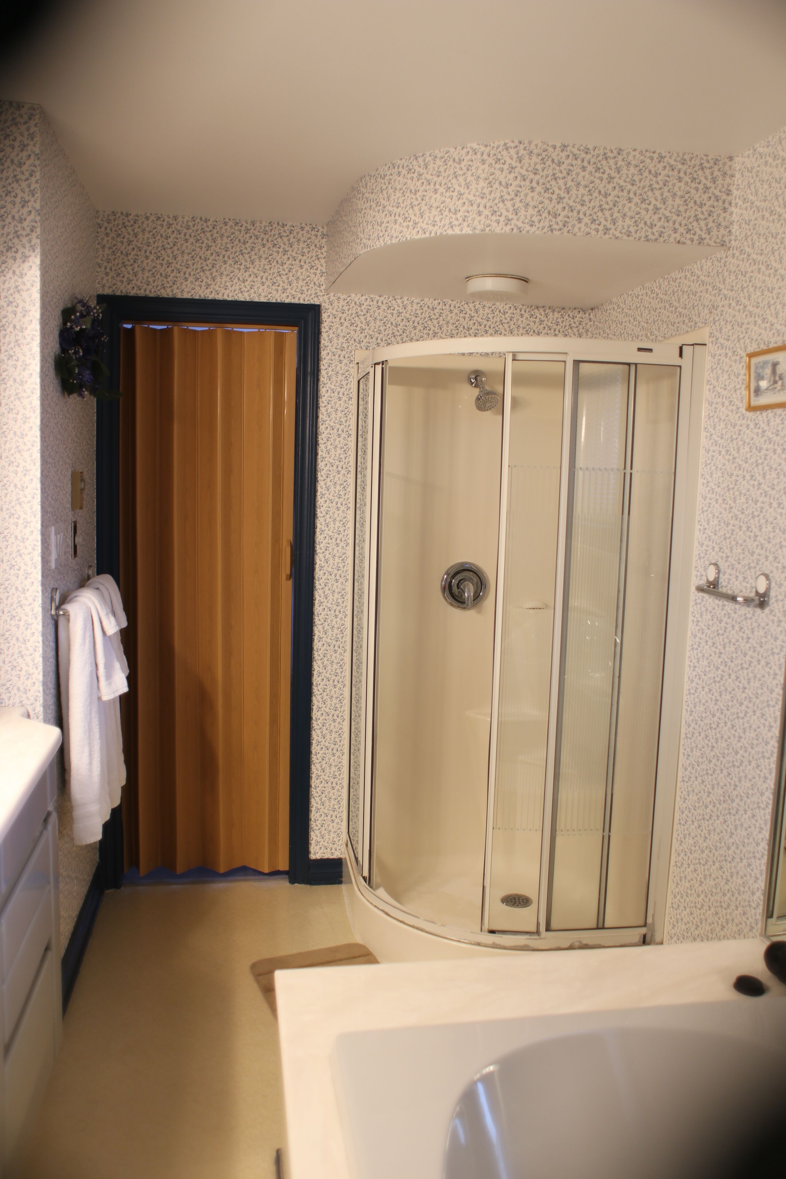 Een badkamer met een douche, toilet en wastafel.