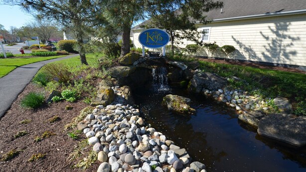 A sign for 'The Keys' hotel with a small waterfall and a stone pathway leading to it. - Less than 2 miles to the beach and boardwalk! (Rehoboth Beach)
