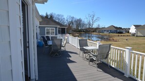 A deck with outdoor furniture and a view of a lake. - Less than 2 miles to the beach and boardwalk! (Rehoboth Beach)