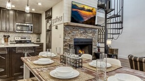 Una cocina moderna con gabinetes de madera oscura, electrodomésticos de acero inoxidable y una chimenea de ladrillo.