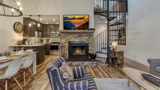 Una sala de estar moderna con chimenea, comedor y cocina.
