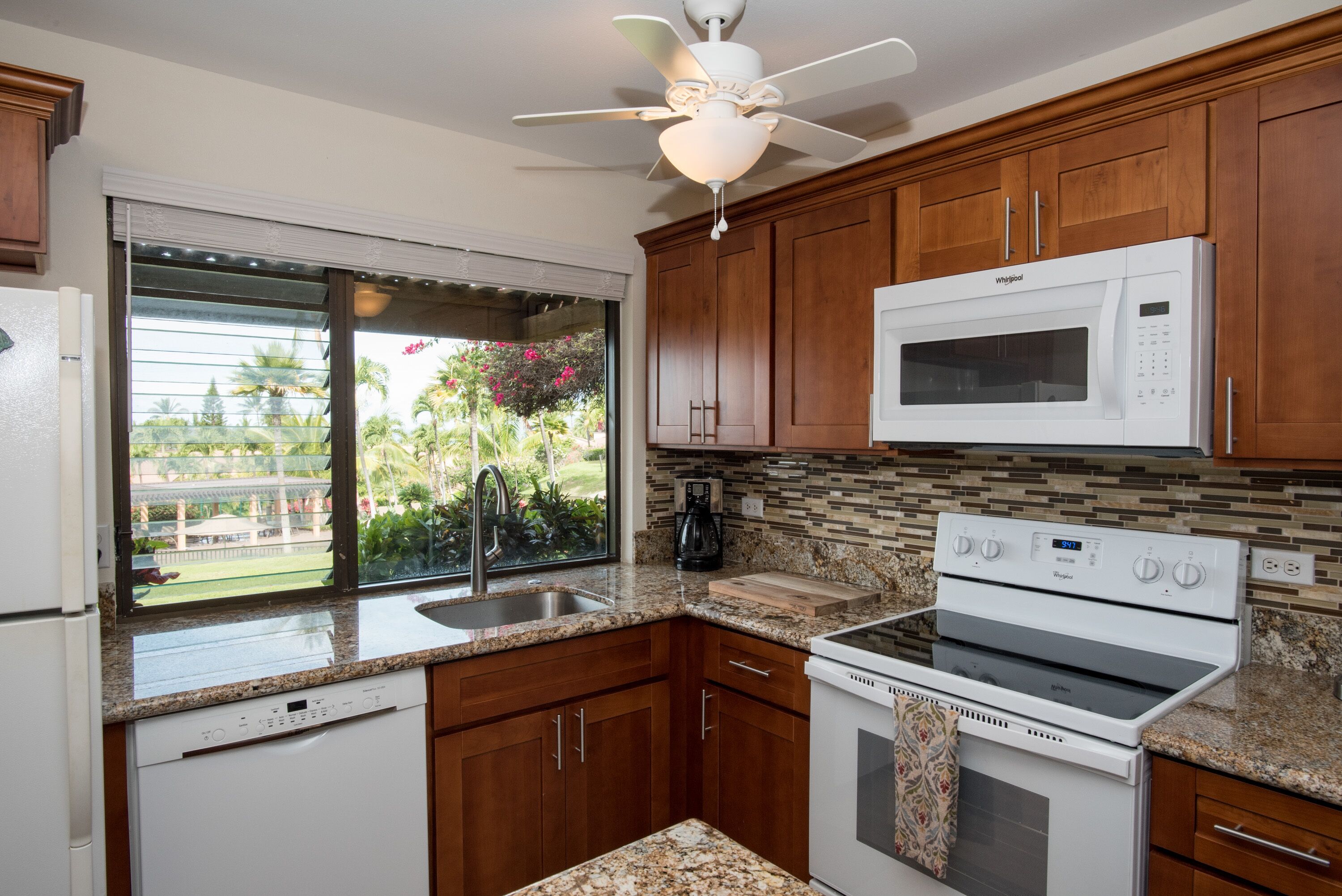 A kitchen with wooden cabinets, a microwave, a stove, and a dishwasher.