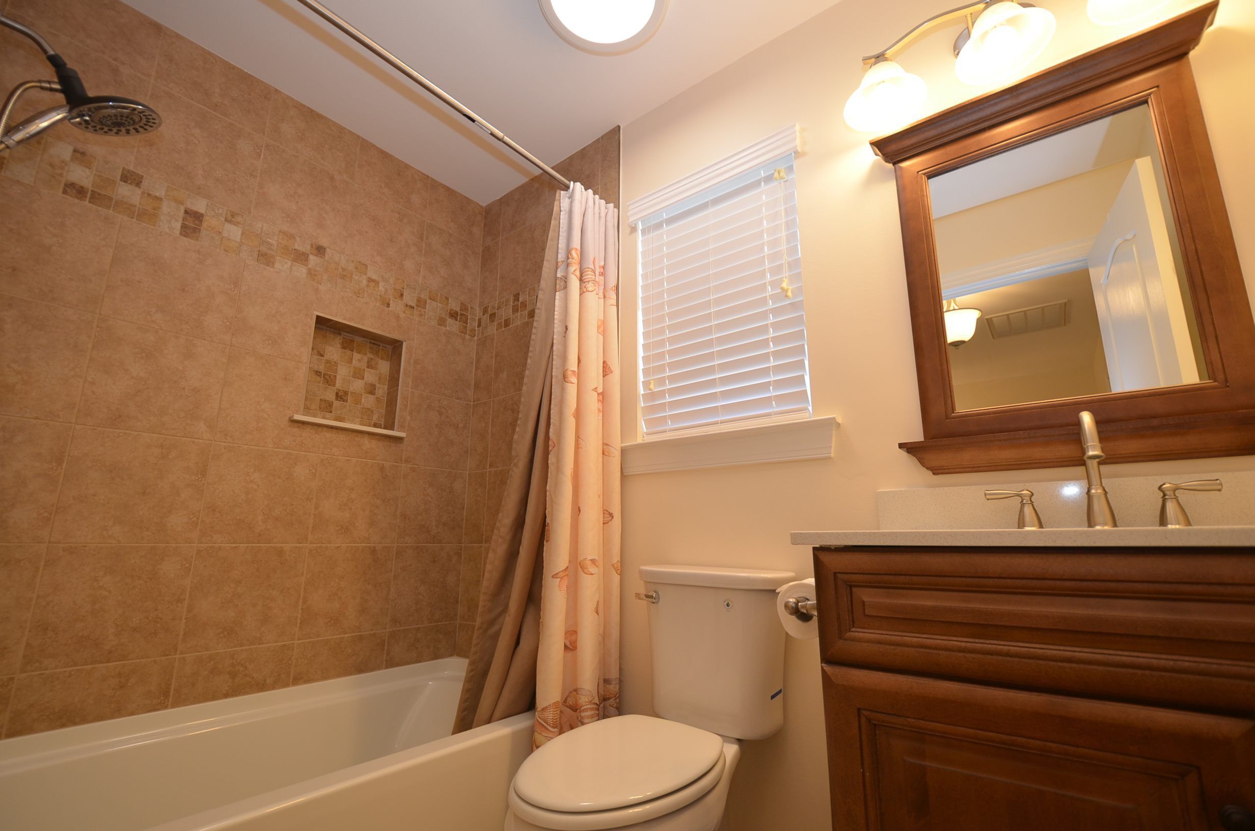 A bathroom with a bathtub, toilet, and shower.