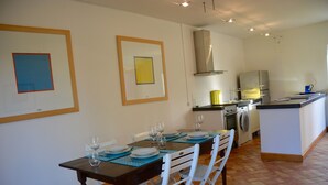 A dining area with a table set for six, a kitchen with modern appliances, and a laundry area. - Villa Nocellara (Castiglione di Sicilia)