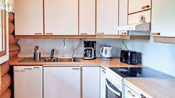 Una cocina compacta equipada con lavavajillas, cafetera, hervidor, tostadora y horno.