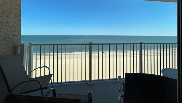 Un balcón con vista a la playa y al océano.