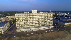 Ein mehrstöckiges Hotel mit Innenhof, Balkonen und Parkplatz.