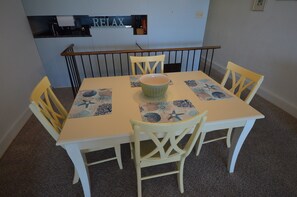 A dining table with four chairs, a bowl, and placemats with a nautical theme. - Edgewater House - Ocean Front Units With Spectacular Views! (Rehoboth Beach)