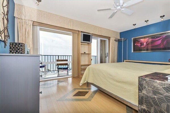 Ein Hotelzimmer mit Bett, Schreibtisch, Stuhl, Fernseher und einem Balkon mit Blick.