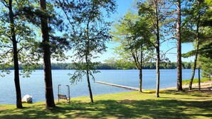 A lakeside park with a wooden dock, a bench, and a kayak. - Reggie's Northwoods Retreat (St Germain)