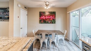 A dining area with a wooden table and white chairs, a ceiling fan, and a large window with a view of trees. - ★LUXURY RETREAT★ Walk to Hyde Park, SOHO, Bayshore (Tampa)