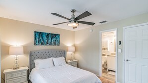 A bedroom with a bed, two bedside tables, a ceiling fan, and a bathroom visible through an open door. - ★LUXURY RETREAT★ Walk to Hyde Park, SOHO, Bayshore (Tampa)