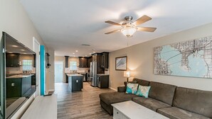 A modern kitchen with dark cabinets, a central island, and a ceiling fan. - ★LUXURY RETREAT★ Walk to Hyde Park, SOHO, Bayshore (Tampa)
