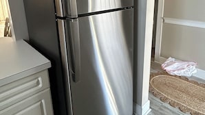 A stainless steel refrigerator in a kitchen with white cabinets and a wooden floor. - Close enough to the beach but far enough from all of the noise! No pet fee! (Myrtle Beach,)