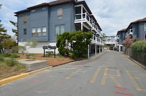 A residential street with blue buildings, a bench, and a sign indicating a private area.