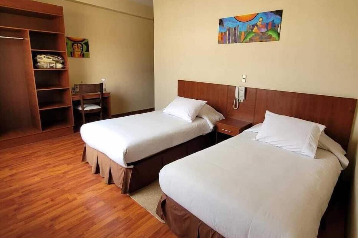 Habitación con 2 camas individuales, 2 camas individuales, vista a la ciudad | Escritorio, tabla de planchar con plancha, wifi gratis y ropa de cama