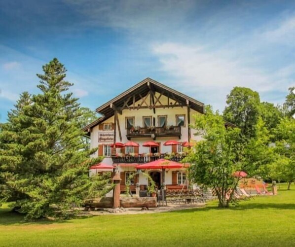 A traditional chalet-style building with a balcony and outdoor seating area.