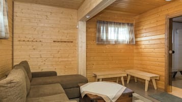 Un interior de madera con un sofá, un banco y una pequeña mesa.