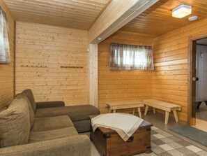 A wooden interior with a sofa, a bench, and a small table. - Villa kaisla by Interhome (Juva)