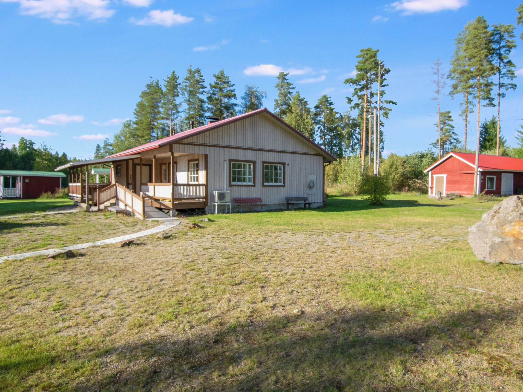 A single-story building with a porch and a small attached structure.