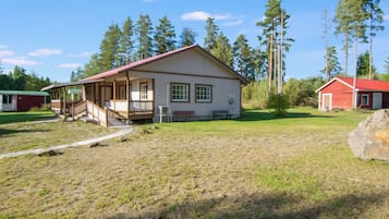 A single-story building with a porch and a small attached structure.