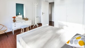 A bedroom with a bed, a white dresser, a mirror, a hanging light fixture, and a wardrobe. - Le Clos Marin by Interhome (Saint Cyr sur mer Les Lecques)