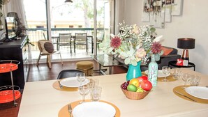 A dining area with a table set for two, a vase with flowers, and a fruit basket. - Le Clos Marin by Interhome (Saint Cyr sur mer Les Lecques)