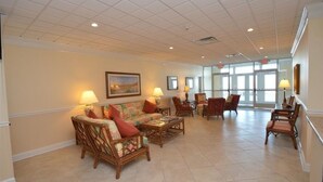 Eine geräumige Lobby mit hoher Decke, bequemen Sitzgelegenheiten und großen Fenstern, die für natürliches Licht sorgen.