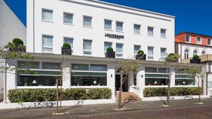 A white building with the sign "LOGIERHAUS" on the facade, featuring multiple windows and a central entrance with steps. - Comfort Double Room - Logierhaus Oystercatcher (Norderney)