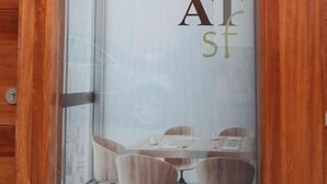 A wooden-framed window with a view of a dining area featuring a table and chairs. - Tourist apartments (Mota del Cuervo)