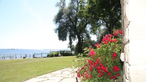 A stone pathway leading to a grassy area with a view of the water and trees. - Home of 1000island#3-Directly on STL river private beach FREE boat docking (Gananoque)
