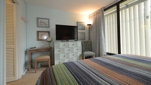 A hotel room with a bed, a desk, a television, a dresser, and a chair. - Edgewater House - Ocean Front Units With Spectacular Views! (Rehoboth Beach)