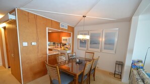 Habitación de hotel compacta con comedor, kitchenette y vistas a la ciudad.