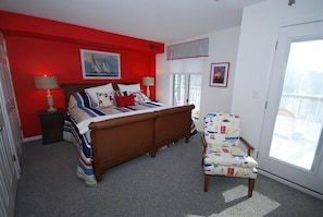 Une chambre à coucher avec un lit, une chaise et une fenêtre.