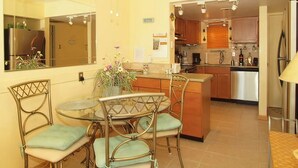 Una cocina compacta con comedor, que incluye una mesa redonda, sillas y un ventilador de techo.