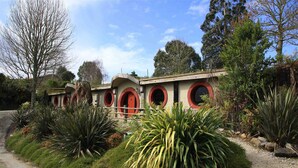 Un bâtiment doté de fenêtres rondes et d’un chemin bordé de gravier.