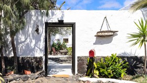 A white-walled building with a doorway, a hanging sign, and a red mailbox. - Rustic Home Short Drive from Beach with Pool, Terraces & Garden (Güime)