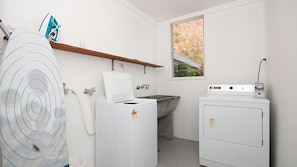 Un cuarto de lavandería con lavadora, secadora y lavabo.